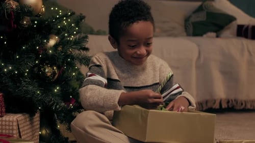 Boy Excitedly Opening Christmas Gift Box at Home