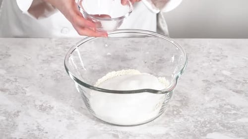 Chef Adding Flour and Sugar Into Glass Bowl