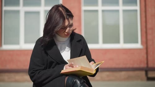 Woman Reading a Book Outside on a Sunny Day