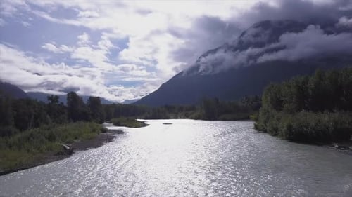 El sol espectral plateado se refleja en el río Bella Coola, valle nublado