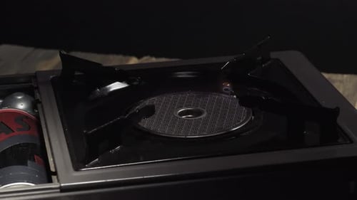 Portable Gas Stove Igniting on Wooden Surface