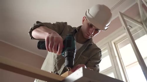 male craftsman works in a workshop with wood. power tool. close-up
