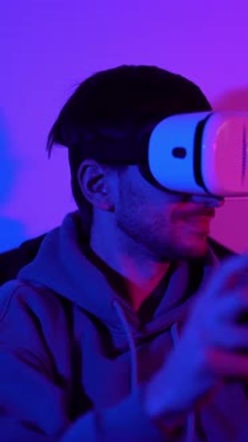 Männlicher Gamer mit Virtual-Reality-Brille und Controller beim Spielen