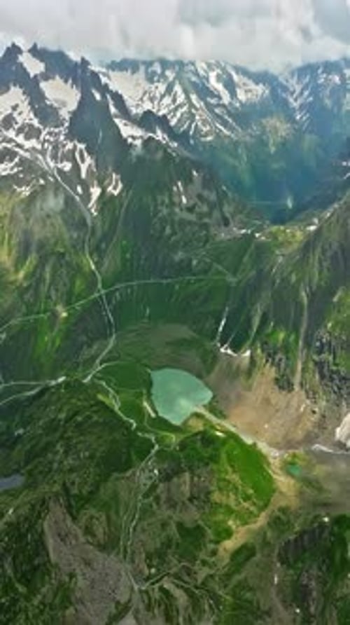 Drone Flies Over Green Picturesque Valley with Mountains in the Background High Mountains Famous