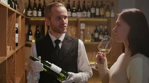 Sommelier Helping to Choose Collection Wine to Young Woman