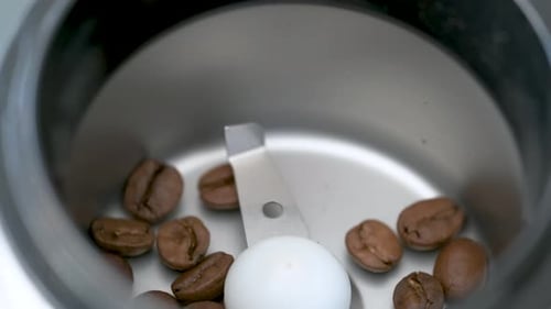 Pouring Coffee Beans into a Grinder