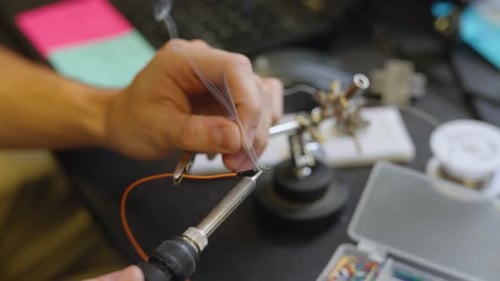 Der Elektriker lötet und schweißt Drähte zusammen, um elektronisch Geräte zu reparieren und zu bauen.