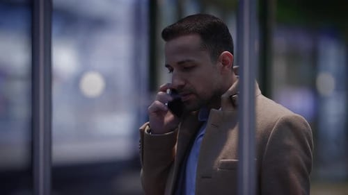 Man Talking on Phone and Smoking at Night