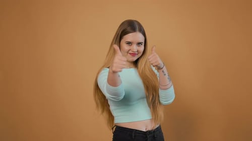 Young Woman Smiles and Gives Two Thumbs Up