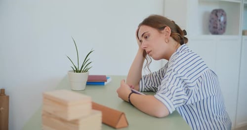Woman Sits, Looking Down at a Book