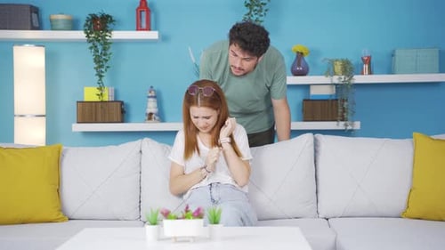 Upset Woman on Sofa with Angry Man