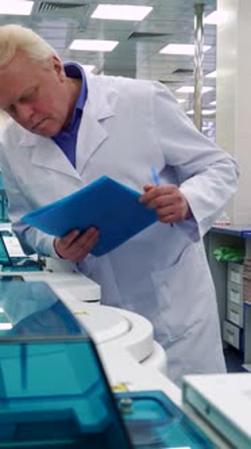 Scientist Reviews Notes in Clinical Laboratory