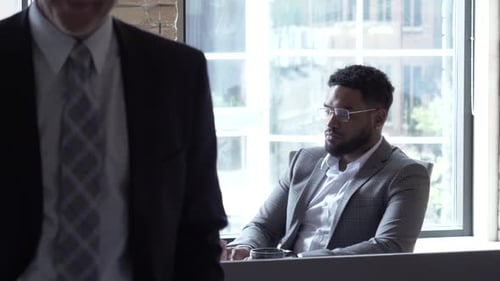 Un jeune homme d'affaires travaille assidûment à l'ordinateur dans un bureau moderne et lumineux