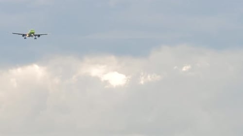 Airplane Flying Across Cloudy Sky During Daytime