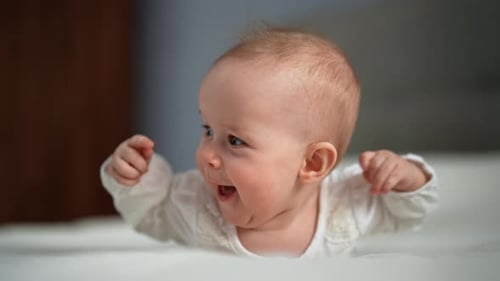 Adorable Fair-Haired Infant Lays and Arches Back