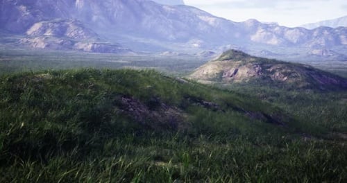 Natural Landscape with Rolling Hills and Distant Mountains in Clear Daylight
