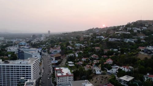 Aerial view of a sunset above a hillside neighborhood, the west Hollywood cityscape and the Los Ange