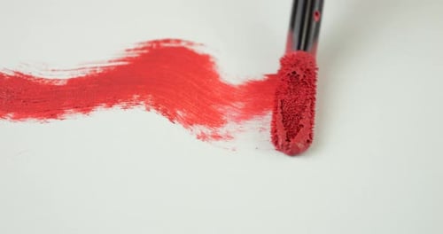 Brush strokes of Cosmetic liquid lip red gloss on isolated white background.