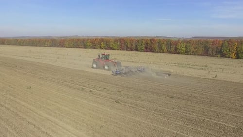Big red combine working on the field cultivating and applying nitrogen ASP