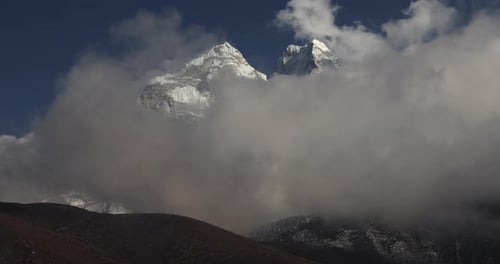 Timelapse over the mountains in Nepal with large white clouds.
