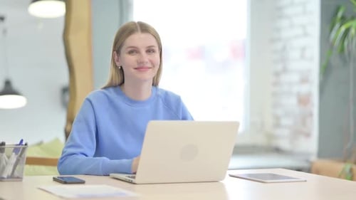 Smiling Woman Works at Laptop in Office
