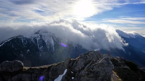 Dramatic Clouds Rolling Over Snow-Capped Mountain Peaks