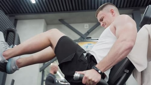 Muscular Man Exercising Legs on Leg Press Machine