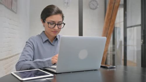 Woman Working on Laptop at Office Desk