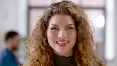 Attractive Smiling Woman with Curly Hair in Office