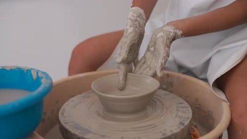 Woman Creating Pottery Bowl on a Wheel