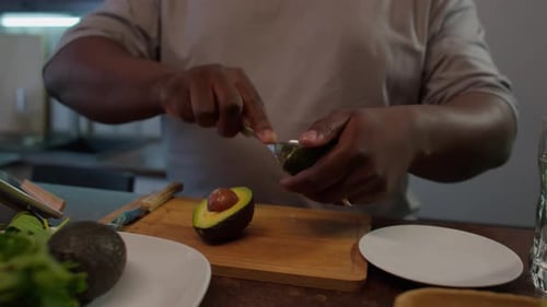 Person Prepares Fresh Avocado in Kitchen