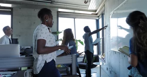 Creative Businessman Leading Meeting at Whiteboard in Office Brainstorming