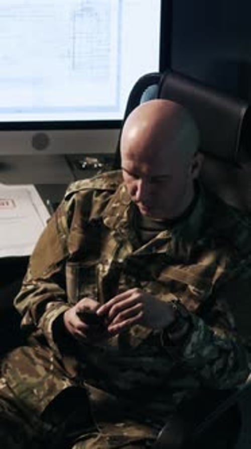 Military Officer Using Phone at Workplace in Command Center, Vertical