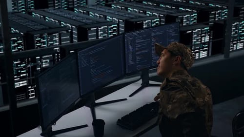 Vue latérale d'un militaire asiatique ayant mal au dos lors de l'écriture de code dans un centre de données