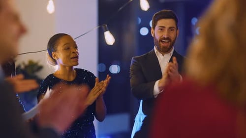 Diverse group of people clapping at an indoor party