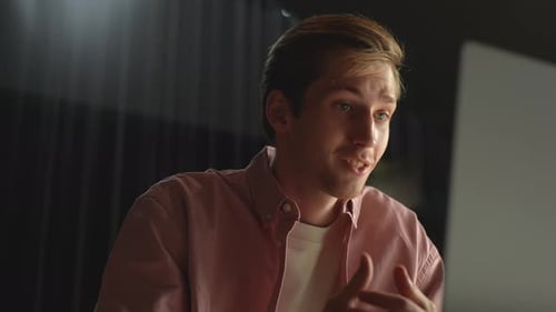 Closeup Lowangle View of Positive Young Man Using Laptop for Online Communication in Social Media at