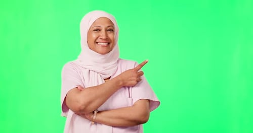 Nurse face, woman pointing and green screen isolated on studio background for islamic healthcare
