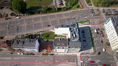 Aerial view of a bustling city intersection with diverse buildings and traffic.