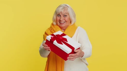 Happy Senior Woman Giving Gift Box