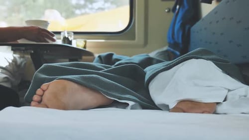 Un jeune homme dort dans un wagon