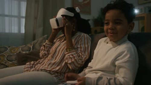 Woman Uses VR Headset, Boy Watches