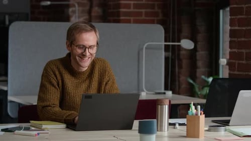 Porträt eines männlichen Entwicklers mittleren Alters mit Laptop im modernen Büro