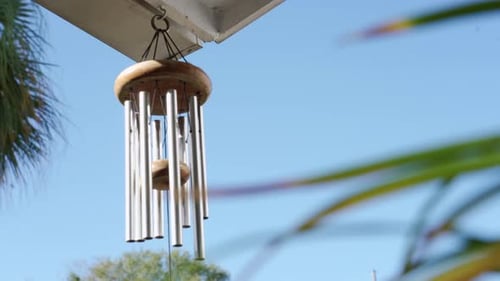 Calming and relaxing view of a wind chime blowing in a tropical garden
