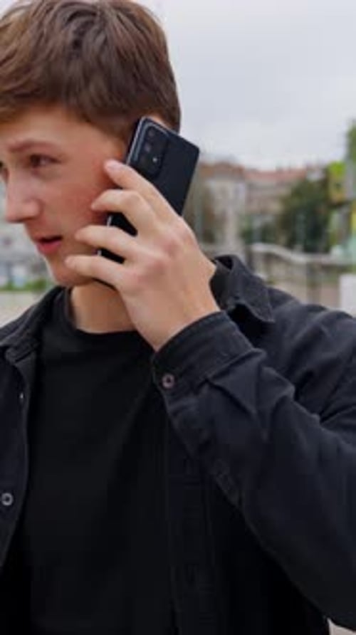 Young Man in City Talking on Smartphone