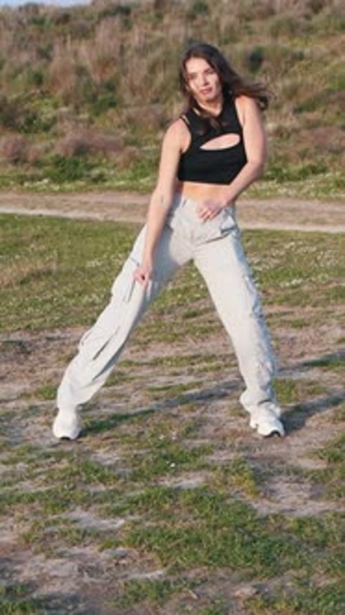 Young Woman Dances in a Grassy Field