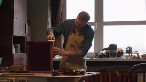 Craftsman Sanding Wood during Furniture Renovation in Workshop