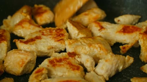 Chicken Pieces Cooking in Pan with Spatula
