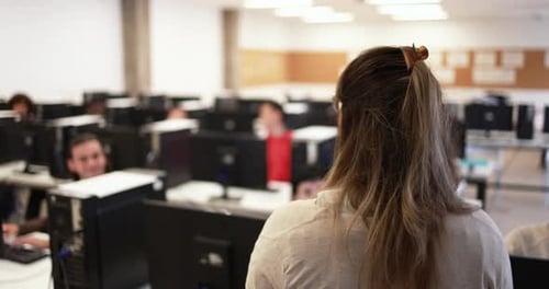 Mature professor teaching students in a computer lab at a USA university