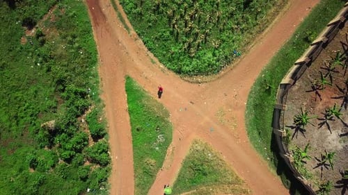 Top Down View Of A Girl Walking Through A Village To Collect Water In A Jerrycan In Africa. - aerial