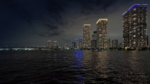 City skyline and skyscrapers at night over water